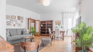 Una sala de estar con un sofá gris, una mesa de centro de madera y una estantería.