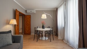 Un salon moderne avec une table à manger ronde, un canapé, une lampe et un lampadaire.