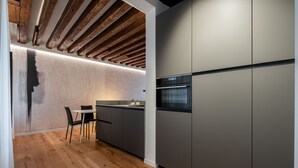 A modern kitchen with wooden beams, a built-in island, and a sleek refrigerator.