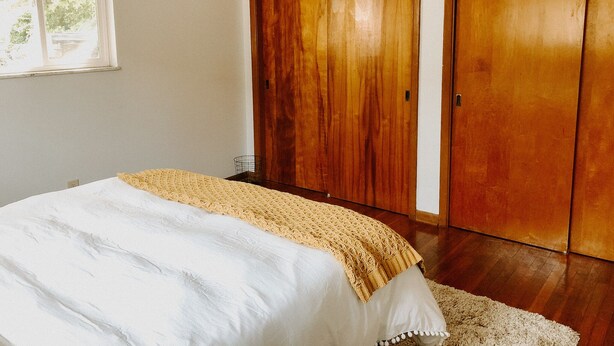 Une chambre à coucher avec un lit, une fenêtre et des armoires en bois.
