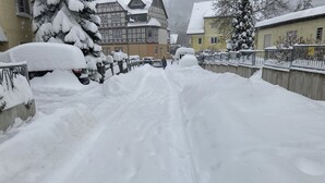 A snow-covered street with houses on both sides.