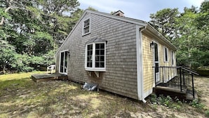A single-story house with a front porch, a small deck, and a covered entryway. - 3BR/1BA Eastham cottage w/ backyard, A/C & WiFi (Eastham)