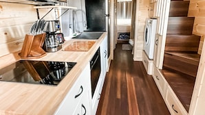 A compact kitchen with wooden cabinets, a sink, a stove, and a microwave. - Luxury Tiny Home/Base Camp to Ouray, Telluride/3 Queen beds/Washer & Dryer/Smart TV/Hot Tub Access/Patio w/Mountain Views/ Fire Pit/11 mi to Airport (Montrose)