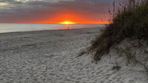 A beach with sand dunes and a sunset in the background. - Love to fish! We have a dock  (Oak Island)