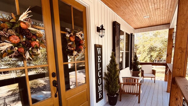 A wooden porch with a welcome sign, a small potted plant, and a bicycle in the background. - Love to fish! We have a dock  (Oak Island)