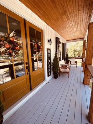 A wooden porch with a welcome sign, a small potted plant, and a bicycle in the background. - Love to fish! We have a dock  (Oak Island)