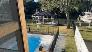 A swimming pool with a wooden deck and a gazebo in the background. - Love to fish! We have a dock  (Oak Island)