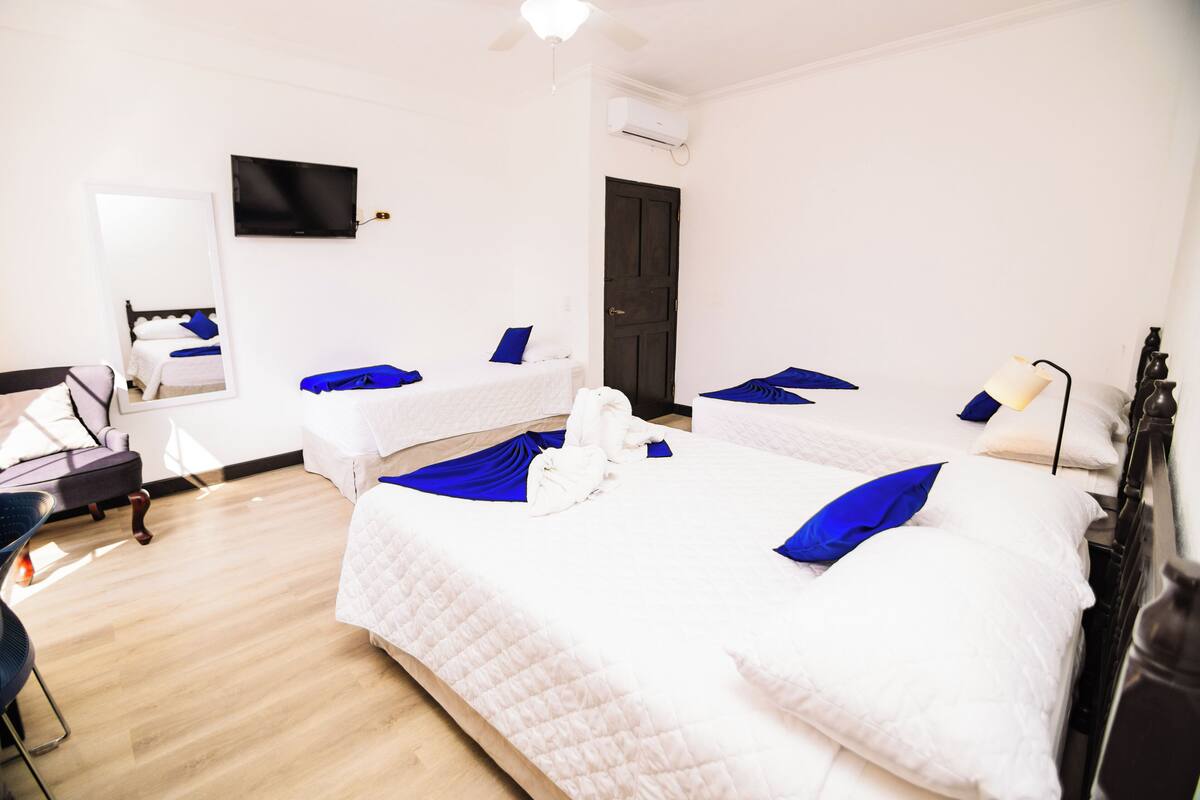 A hotel room with two beds, a flat-screen TV, a desk, and a chair.