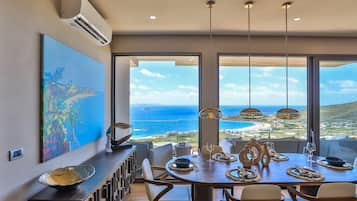 Enjoy meals with a view at this dining area, featuring a large round table for four and a minimalist design.
