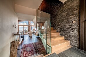 Stunning staircase leads to a spacious area with a comfortable seating arrangement and a large window offering a view of the outdoors.