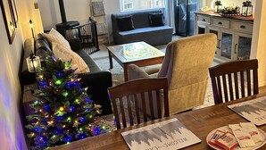 Una sala acogedora con chimenea, un árbol de Navidad y un comedor con individuales.