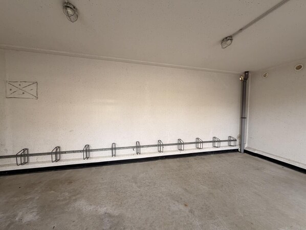 A large, empty room with a long, narrow hallway and a door on the right.