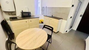 A compact kitchen with a round table, two chairs, a microwave, and a sink. - Suite Menotti - Sanremo (Sanremo)