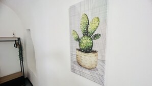 A wall-mounted artwork of a cactus in a woven pot. - Suite Menotti - Sanremo (Sanremo)