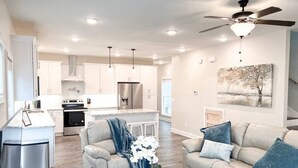 A modern kitchen with white cabinets, a central island, and stainless steel appliances.