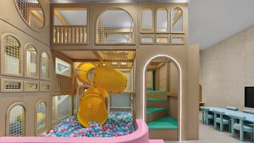 Children can play and relax in this vibrant play area with a slide, ball pit, and play structures.