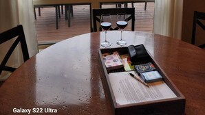 Une table avec deux verres à vin et un plateau d’objets, donnant sur une vue du lac et disposant de sièges à l’extérieur.