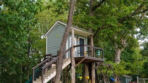 A treehouse with a wooden deck, stairs, and a swing set. - Mountain Veiws, Hot Tub,Treehouse,Gameroom, Child playroom, pet friendly  (Verona)