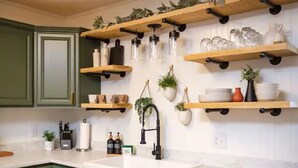 A kitchen with green cabinets, wooden shelves with glassware, and potted plants. - Mountain Veiws, Hot Tub,Treehouse,Gameroom, Child playroom, pet friendly  (Verona)