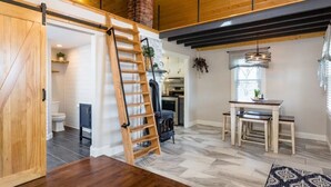 A modern kitchen with a black stove, wooden cabinets, and a hanging plant. - Luxury Farm Cottage, Hot Tub, Sauna,Massage,Shenandoah Views, pet friendly (Weyers Cave)