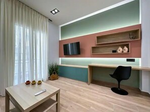 Relax in this stylish living space with a flat-screen TV, desk, and comfortable chair.
