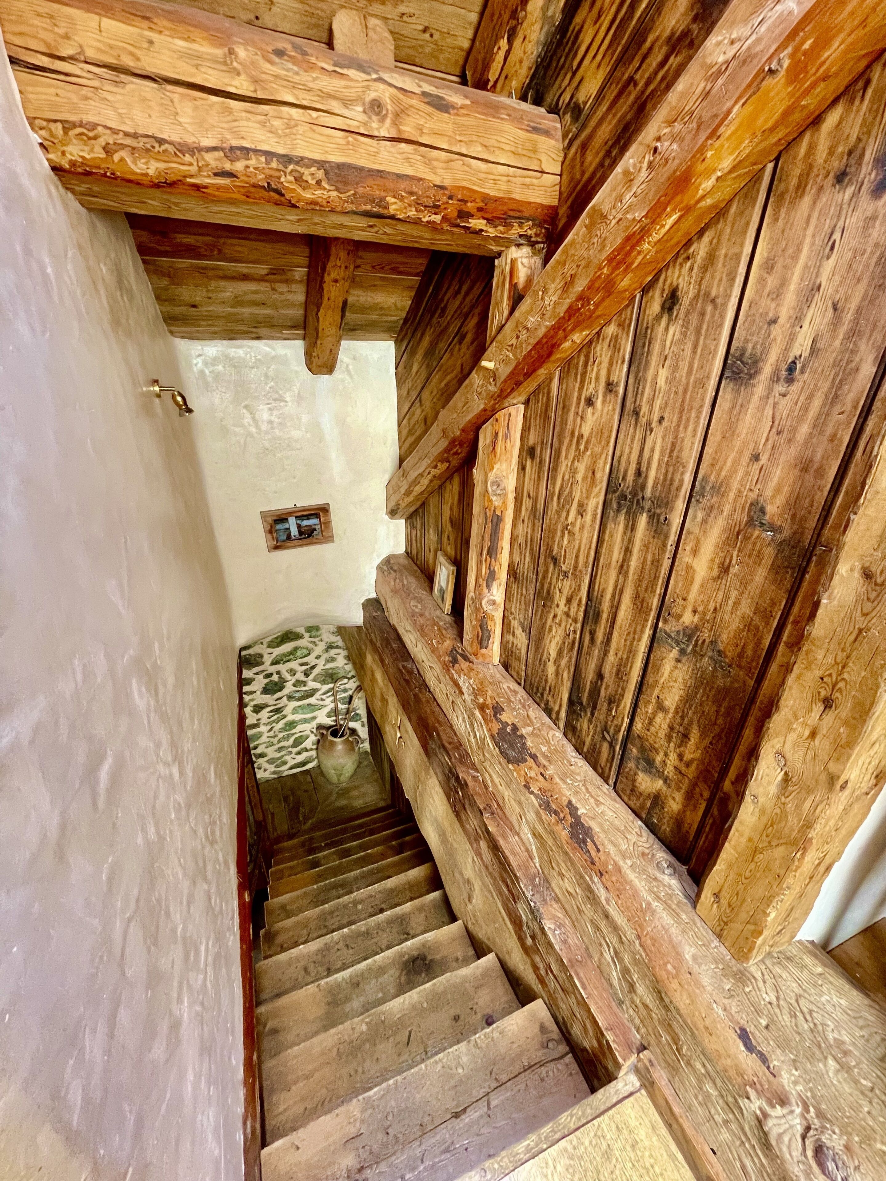 A wooden staircase with a rustic design, leading to a lower level.
