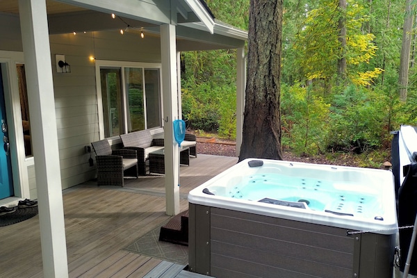 Hot tub with lush forest backdrop.