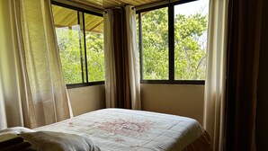 A bed with a floral bedspread, a pillow, and a nightstand.