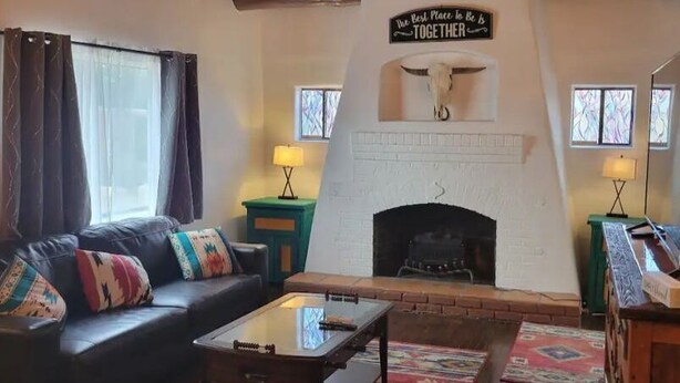 Ein gemütliches Wohnzimmer mit Kamin, einer Couch, einem Couchtisch und einem Fernseher.
