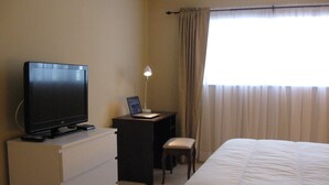A hotel room with a bed, a desk with a laptop, a television, and a chair. - LOVELY APARTMENT 1 MILE TO BEACH - DEERFIELD BEACH - FREE PARKING (Deerfield Beach)