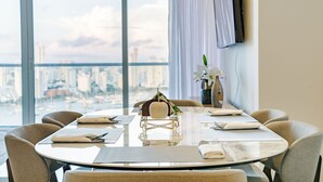 A conference room with a city view, round table, chairs, and a small decorative item. - Condominio H2 (Cartagena)