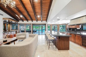 A modern kitchen with a large island, bar stools, and a view of the outdoors. - Midcentury Modern House in Heart of Historic Las Vegas (Las Vegas)