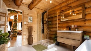 A wooden interior with a bathroom, a mirror, and a sink.