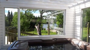 Un bain à remous avec vue sur un lac et une terrasse en bois.