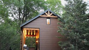 A rustic cabin with a wooden exterior, a pitched roof, and a small window.
