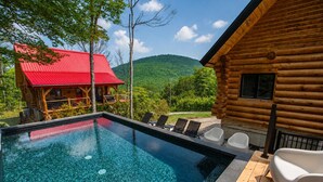 A log cabin with a pool and outdoor seating. - Private Heated Pool | Spa | Party | The Animal (Saint-Philémon)
