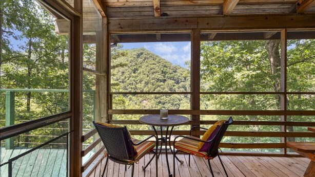 A wooden deck with a table and chairs, overlooking a forested hillside. - Grandpa Dans Cabin+Mtn River view 34 acre retreat (Marshall)