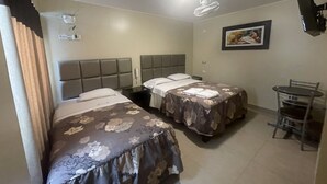 A hotel room with two beds, a small table, and a chair. - Terrazas Suite (Lima)