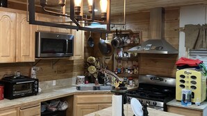Una cocina con armarios de madera, horno empotrado, estufa y refrigerador Coors.