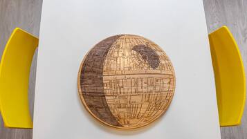 A round wooden table with a detailed map design, surrounded by yellow chairs.