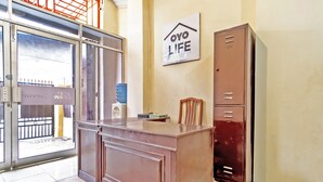 Een kamer met een houten kast, een waterdispenser en een bordje met de tekst 'OYO LIFE'.