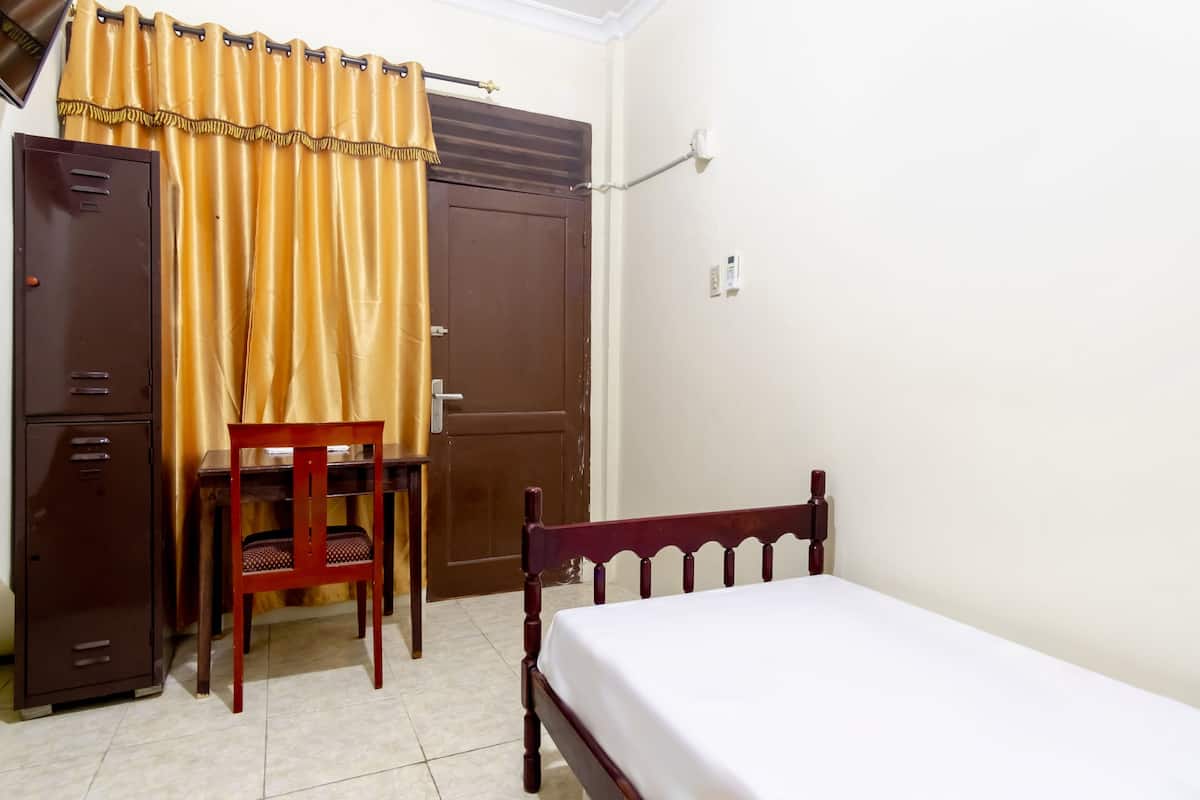 Une chambre à coucher comprenant un lit, un bureau, une chaise et une armoire.