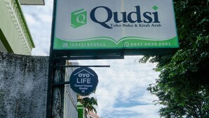Letrero de Qudsi Toko Buku & Kitab Arab con números de contacto.