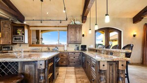 Una cocina amplia con una isla grande, armarios de madera y vistas al exterior.