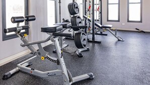 A gym with weightlifting equipment, large windows, and a speckled black floor. - Wariruri 1-14 BRAND NEW Apartment, private patio! (Noord)