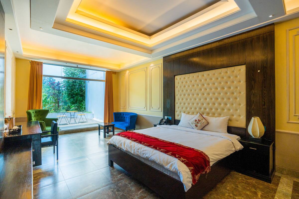 A spacious bedroom with a large bed, a desk, and a chair.