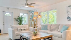 A living room with a beige sofa, a wooden coffee table, and a ceiling fan. - Sea Glass Secrets by Avantstay 3 Mins to Beach (Key West)