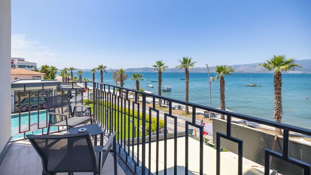 Un balcon avec une piscine, des palmiers et une vue sur la mer.
