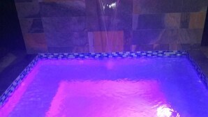 A rectangular pool with a stone border and a water feature at the top. - Casa Bird Cage in Fajardo's Paradise, a rainforest like retreat! (fajardo)