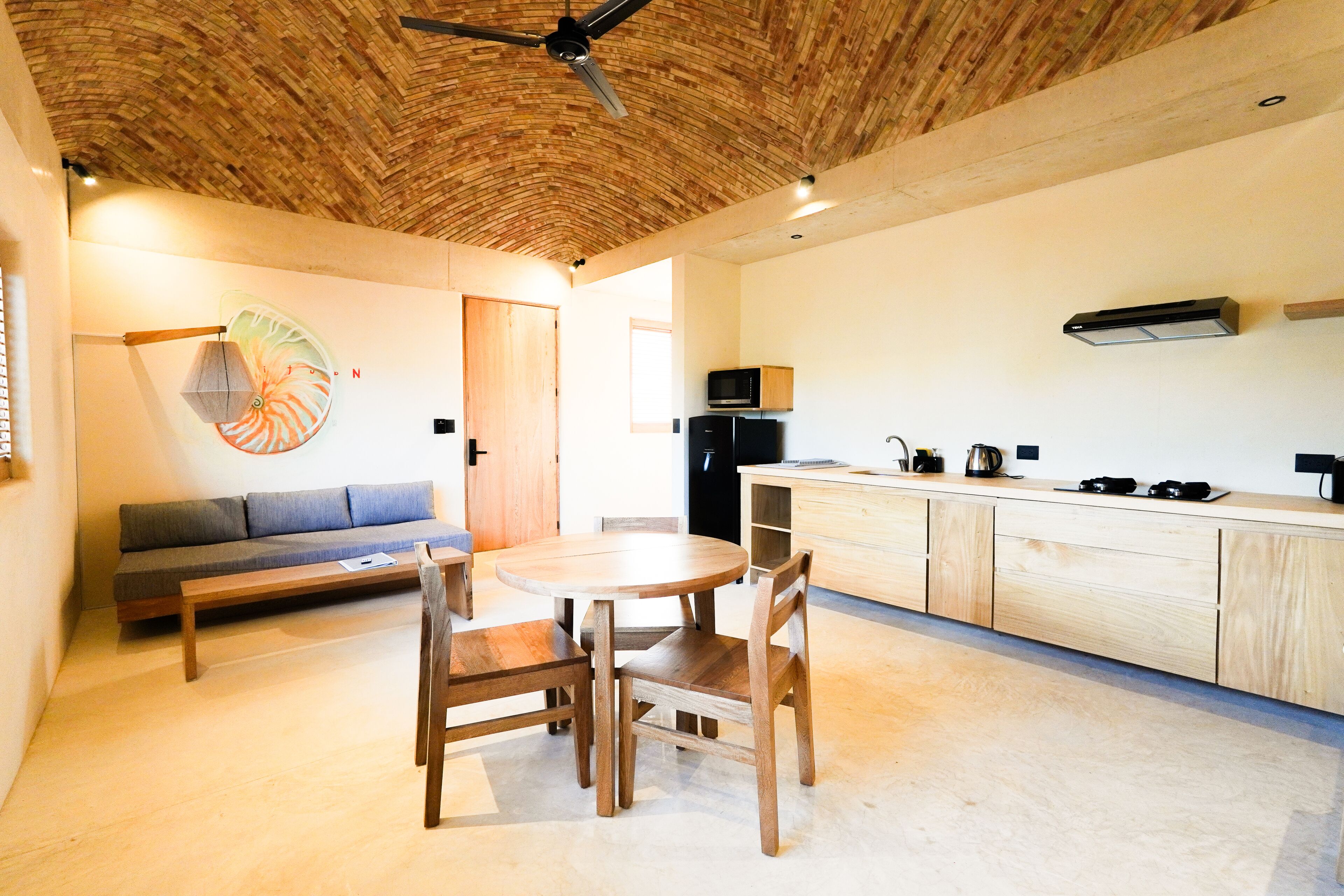 Uma cozinha moderna com armários de madeira, uma mesa de jantar e um ventilador de teto.